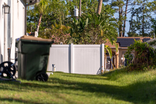 White vinyl fence surrounding private property grounds for backyard protection and privacy in southern Florida.