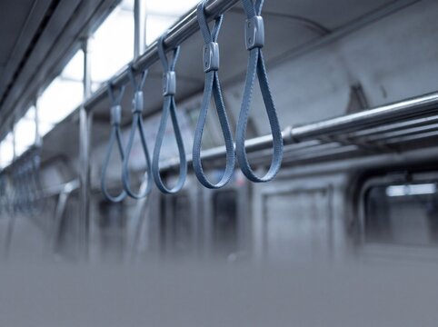 Row of empty subway hand straps swaying in a moving train