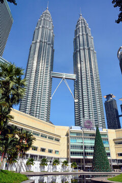 Kuala Lumpur, Malaysia &ndash; November 28, 2015. Petronas Twin Towers and KLCC Park in Kuala Lumpur, Malaysia. View with surrounding buildings, vegetation, pool and people.