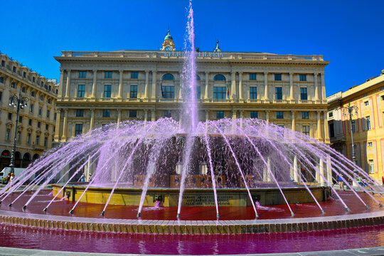 Genoa, Italy &ndash; July 9, 2015. Fountain with pink water at Piazza De Ferrari in Genoa, Italy. View with surrounding historic buildings.