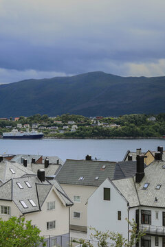 Alesund city roofs, ocean bay and surrounding mountains, Norway. Scandinavian cityscape with traditional coastal houses.