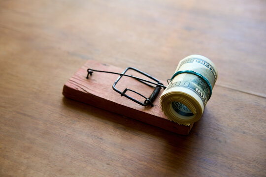 Hundred dollar bills caught in wooden mousetrap
