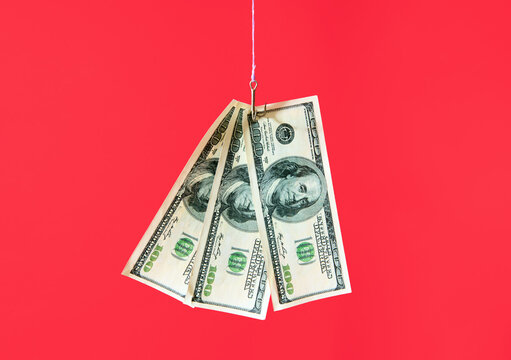 Dollar bills on hook over red background