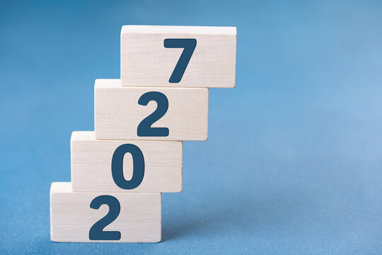 2027 Happy New Year. Wooden cube block steps growth 2027 on blue. Concept 2027 New Year background. Business, resolutions, goals, inspiration, success, ideas