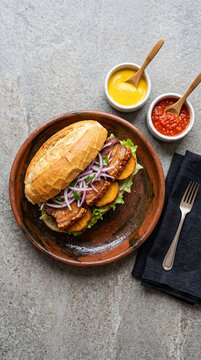 Peruvian Pan con Chicharr&oacute;n on Neutral Stone Surface, Top View Minimal Food Photography