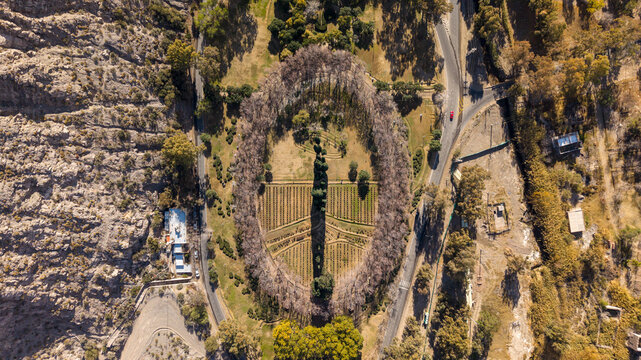 Rivadavia, Argentina - 13 July 2026: Aerial view of Poetas Garden featuring its distinct oval layout, lush trees, and landscaped paths surrounded by rocky terrain.