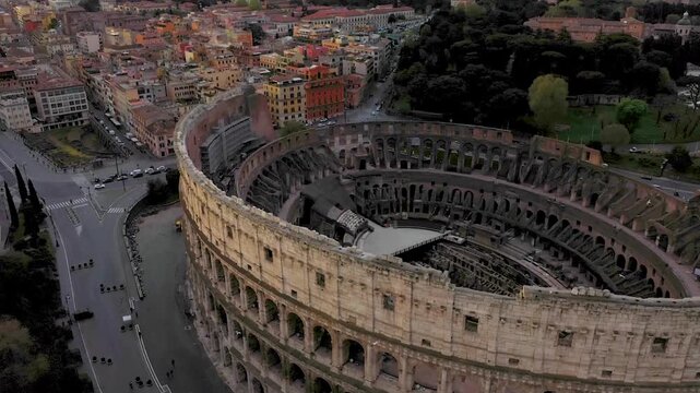 Aerial 4K video footage of Roman Colosseum at sunrise. Ancient amphitheater bathed in golden light.