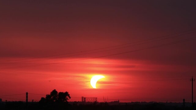 Time-lapse of partial solar eclipse setting over Rome skyline with Gasometer silhouette
