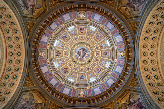 Concentric coffered dome with mosaic saint portraits and arched windows inside Saint Stephen's Basilica in Budapest