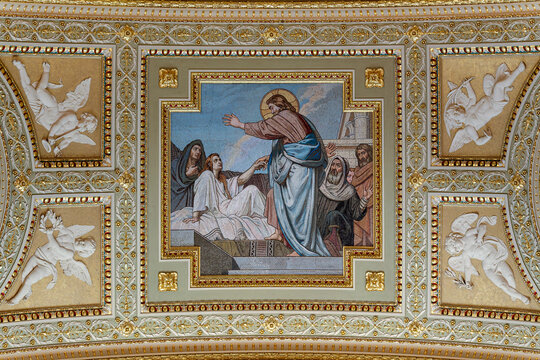Ceiling mosaic panel of a biblical healing scene flanked by cherub reliefs inside Saint Stephen's Basilica in Budapest
