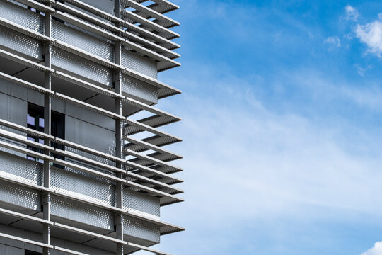 A white modern building stands against blue sky, where architecture, facade lines and minimal detail create a crisp graphic composition