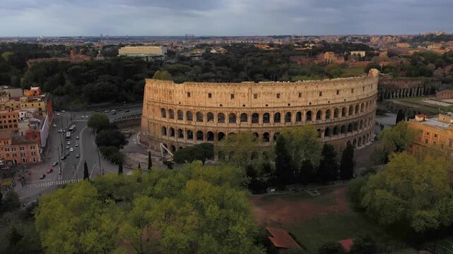 Aerial 4K video footage of Roman Colosseum at sunrise. Ancient amphitheater bathed in golden light.