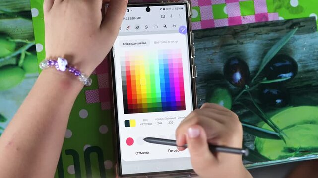 Focused girl uses touch screen tablet with smart pen tool. Cute artistic kid creates beautiful colorful drawing outdoors. - village of Thorin, Zhytomyr region, Ukraine, July 17, 2026 editorial