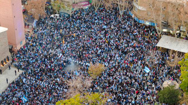 San Juan, Argentina - 15 July 2026: Aerial view of Plaza 25 de Mayo filled with a large crowd of people waving Argentine flags in the city center.