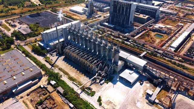 Machinery and buildings site. An industrial area with large machinery and multiple buildings under a clear sky.