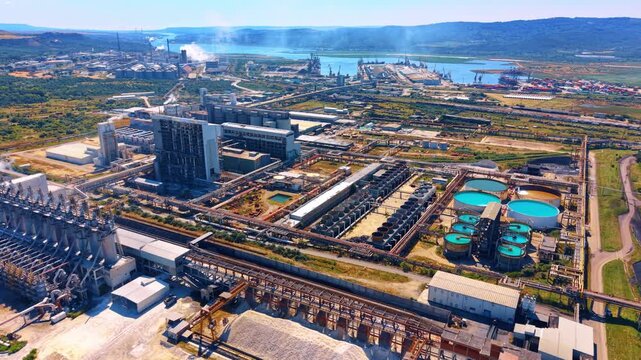 Industrial area with machinery and tanks. A large industrial site is busy with heavy machinery and storage tanks during daylight.