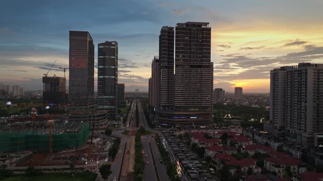 Aerial view of Tay Ho Tay urban development in Hanoi at sunset, featuring modern high-rise architecture, broad avenues, residential areas, and ongoing construction.