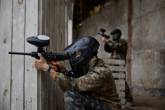 A soldier is taking a defensive position behind the cover during tactical weapon training