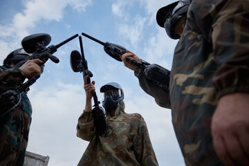Fototapeta premium Group of several soldiers hold their weapons while on a training field