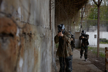 Fototapeta premium Soldiers point their weapons at a third soldier, ready to fire