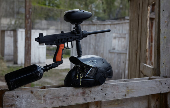 A military pistol on a wooden barrier, resting on a protective helmet