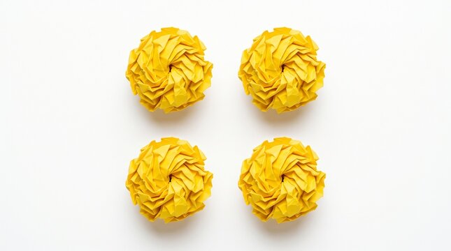 Four yellow crumpled paper balls on clean surface