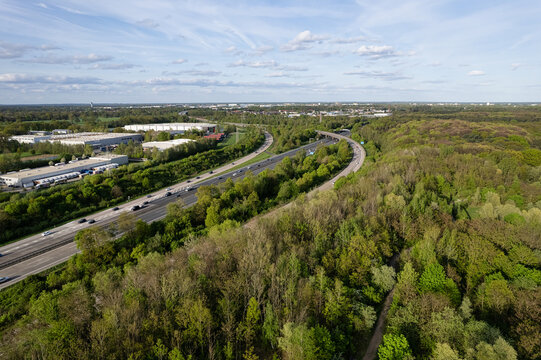 Hanover, Germany - 14 April 2024: Aerial view of the A2 highway and industrial logistics areas near the Mittellandkanal in Hanover-Marienwerder, with surrounding forests and green spaces.