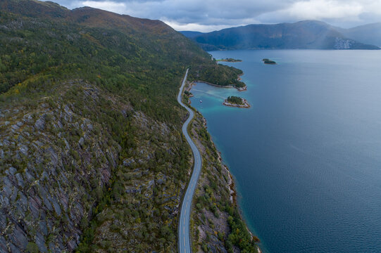 Winding Norwegian coastal road between mountain and fjord