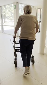 Femme &acirc;g&eacute;e r&eacute;apprenant &agrave; marcher avec un d&eacute;ambulateur