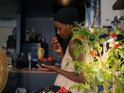 Woman eating freshly harvested tomatoes at home 