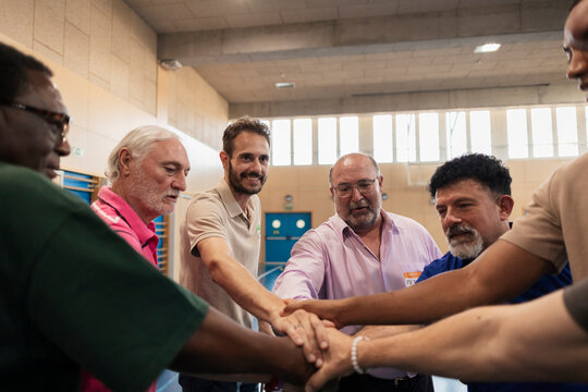 Diverse men joining hands showing teamwork and unity