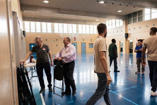 Volunteers setting up chairs in a community sports hall