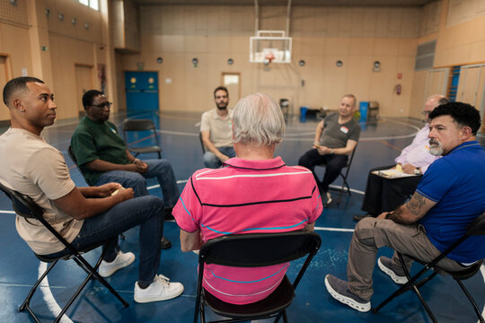 Diverse men forming support group in circle
