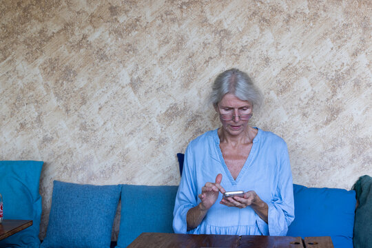 focused senior woman using internet on smartphone or mobile phone