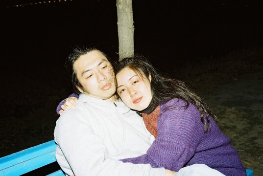Couple Embracing on a Park Bench at Night