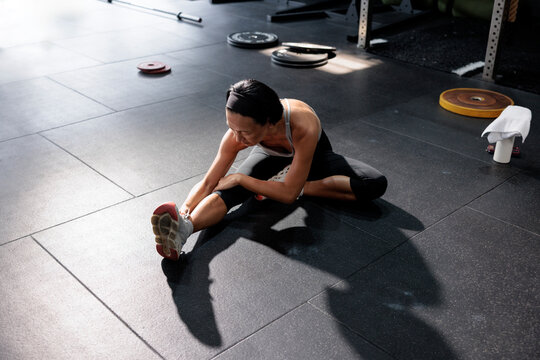 Woman stretching hamstring in modern gym