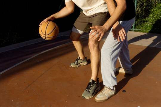 Two young men are playing basketball