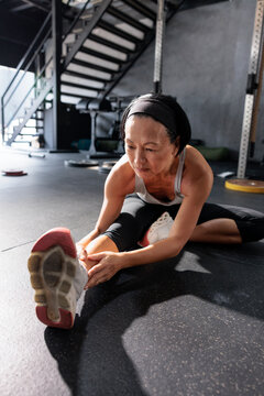 Woman stretching on gym floor before workout