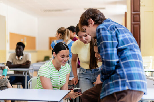 Students sharing content on smartphone in classroom