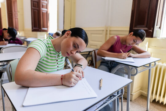 Young female students taking an exam in classroom