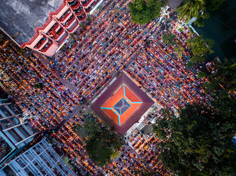 Narayanganj, Bangladesh - 09 November 2024: Aerial view of a large crowd gathered for a religious prayer event in an urban square, with surrounding buildings and trees.