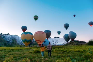 Hot air balloons drifting over the stunning travertine terraces of Pamukkale, Turkey © Fokke Baarssen