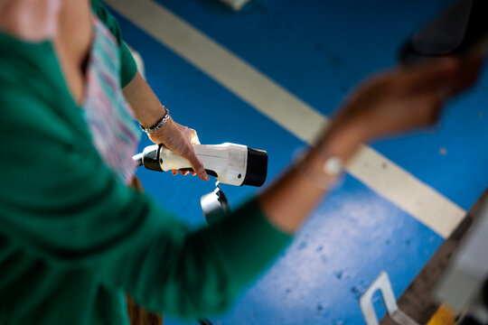 Woman holding electric vehicle charging connector.