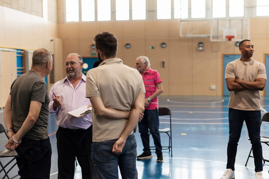 Group of men standing discussing in community hall