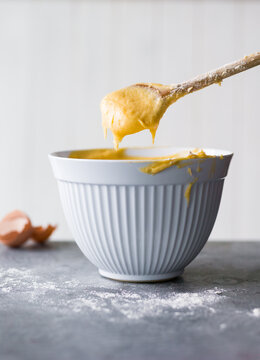 Mixing dough in a bowl with a wooden spoon 