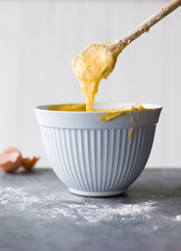 Mixing dough in a bowl with a wooden spoon 