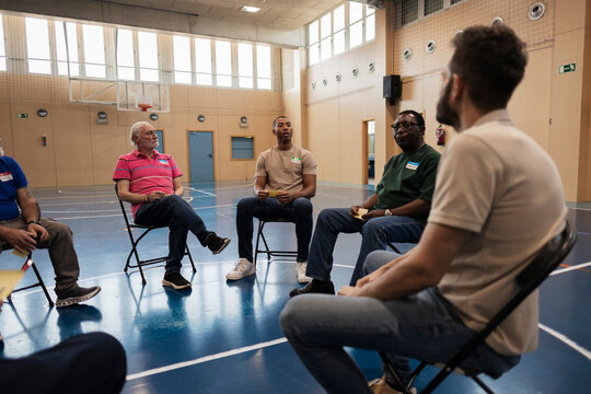 Diverse men participating in community group meeting discussing