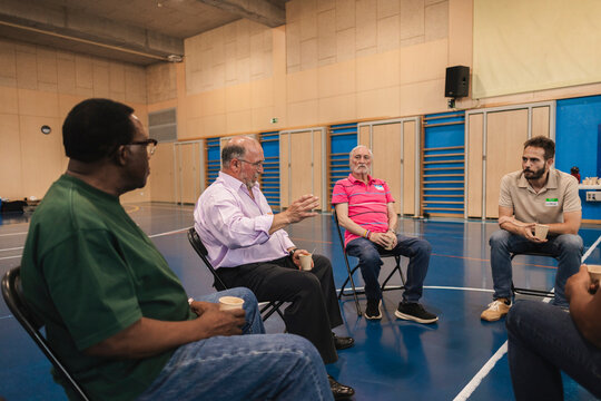 Diverse men forming support group communication circle