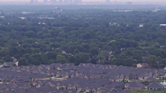 Drone aerial above city of Hilliard, Ohio suburban landscape as a suburb outside Columbus, OH with townhomes, residential units, duplex homes, houses, and rental buildings in middle class neighborhood