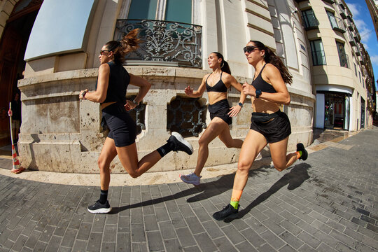 Women run on city street during daytime activity